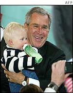 Bush poses for a photograph with baby while campaigning in New Hampshire