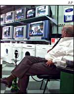 A shopkeeper watches an Al-Jazeera broadcast