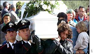 Italian police carry the coffin of one of the victims