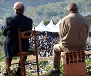 Two men sit watching the crowd in San Giuliano di Puglia