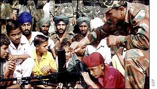 Soldiers at a camp near Amritsar, letting a child inspect his gun
