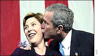 US First Lady Laura Bush (l) receives a birthday kiss from her husband, US President George Bush