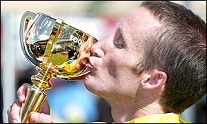 Winning jockey Damien Oliver kisses the trophy after victory in the Melbourne Cup