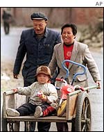 A couple wheeling a child in a handcart 
