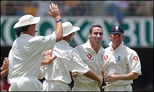 Simon Jones is congratulated by his team-mates after taking England's first wicket