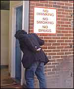 Man walking into toilet with sign