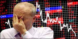 A trader holds his hand over his face