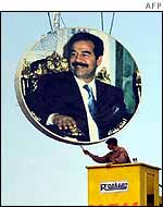 Painter touches up hanging Saddam portrait in Baghdad