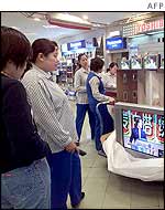 Shoppers look at televisions in shop