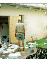 A farmer surveys the damage caused to his farmhouse in the Chinhoyi farming area 