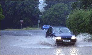 Car negotiates flooded road in Avon