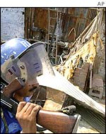 A soldier walks past burnt and looted shops in Gomtipur district, Thursday November 8th