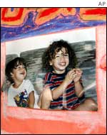 A hand painted mural with a recent photograph of slain children Matan (L) and Noam (R)