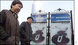 Couple walk past Motorola billboards in Beijing 