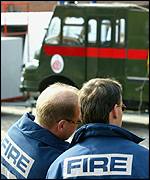 Firefighters protest next to a green goddess