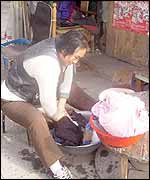 Woman street trader does her laundry as she waits for customers