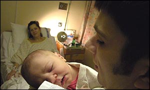 A father, mother and child in a maternity ward