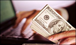 Dollar bills and laptop