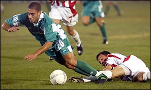 Haifa's Yaniv Katan is challenged by Georgios Amanatidis