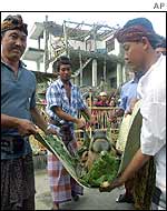 Balinese men carry a cow's head in preparation for sacrifice at the ceremony