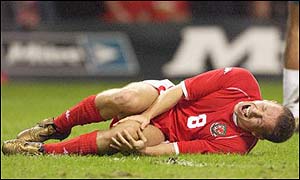 Craig Bellamy holds his knee after a challenge during Wales' 2-1 win over Italy