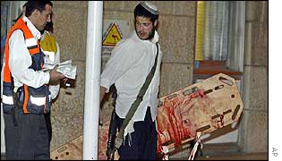 Jewish settlers carry blood-stained stretcher