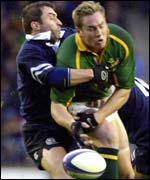 Scotland's Bryan Redpath knocks the ball from the grasp of Robbie Fleck