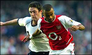 Ashley Cole fends off Robbie Keane during a bruising opening to the North London derby