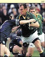 South Arica's Pierre Uys is wrapped up by Scottish hooker Gordon Bulloch