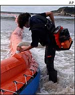 Salvage worker sets up floating barrier