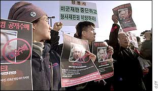 Protesters display posters as they shout 
