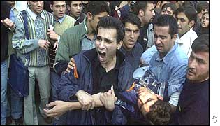 Students carry a wounded man from university protests