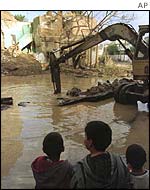 Children look at some of the devastation caused by Operation Desert Fox