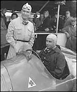 Giuseppe Farina (standing) with Juan Manuel Fangio ahead of the 1950 British Grand Prix