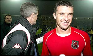 An elated captain Gary Speed shakes hands with manager Mark Hughes following Wales' 2-0 win in Baku