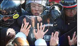 Riot police try to block as South Korean civic group members and students stage an anti-US rally at Camp Casey