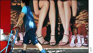 Women pushes trolley past Hong Kong fashion advert