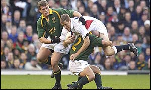 Will Greenwood of England is tackled by James Dalton and Deon Carstens 