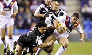 Kevin Sinfield of Great Britain is held up by the Kiwis