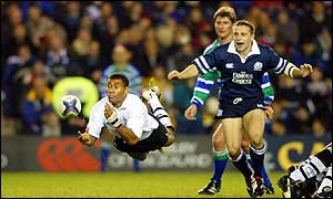 Fiji's Atonia Nariva (left) passes with Scotland's Gordon Ross looking on 