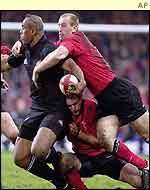 Wales wing Gareth Thomas halts the charge of New Zealand's Jonah Lomu