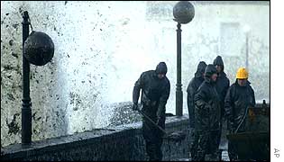 Wave with oil breaks over seafront at Muxia