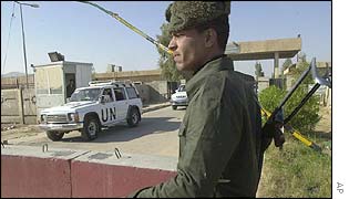 An Iraqi soldier watches UN vehicles as they make their way into the factory