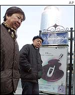Couple walk past Motorola billboard in Beijing 
