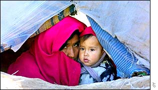 Afghan refugee and her child in tent