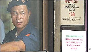 A building security detail mans his post by the door leading to the Canadian Embassy at Makati city, east of Manila