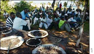 Kenyans listen to a memorial service at the site of the bomb in Mombasa