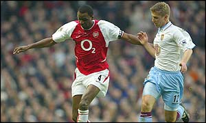 Aston Villa's Thomas Hitzlserger tries to tackle Arsenal midfielder Patrick Vieira