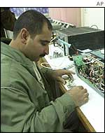 An Iraqi fixes an unidentified machine at the al-Furat facility 
