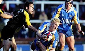 Leeds full-back Dan Scarbrough (centre) tries to get the ball away